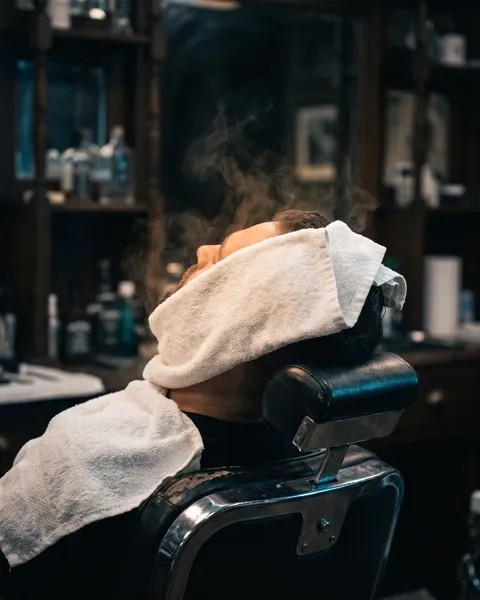 Heißes Handtuch vor der Rasur im Barbershop an der Zülpicher Straße